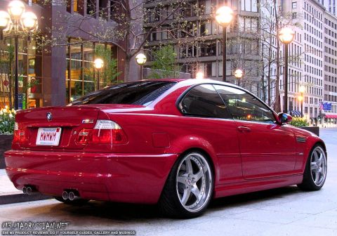 1998 Ford Crown Victoria - A red BMW M3 coupe is parked on a city street with buildings in the background.