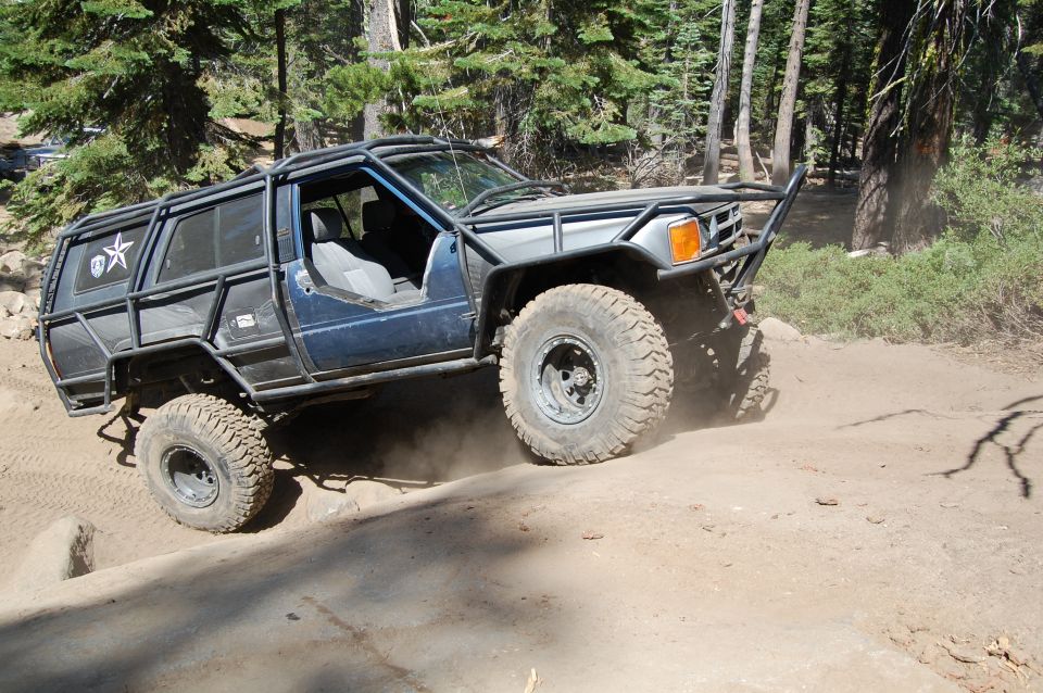 Off-road vehicle with external roll cage on dirt trail
