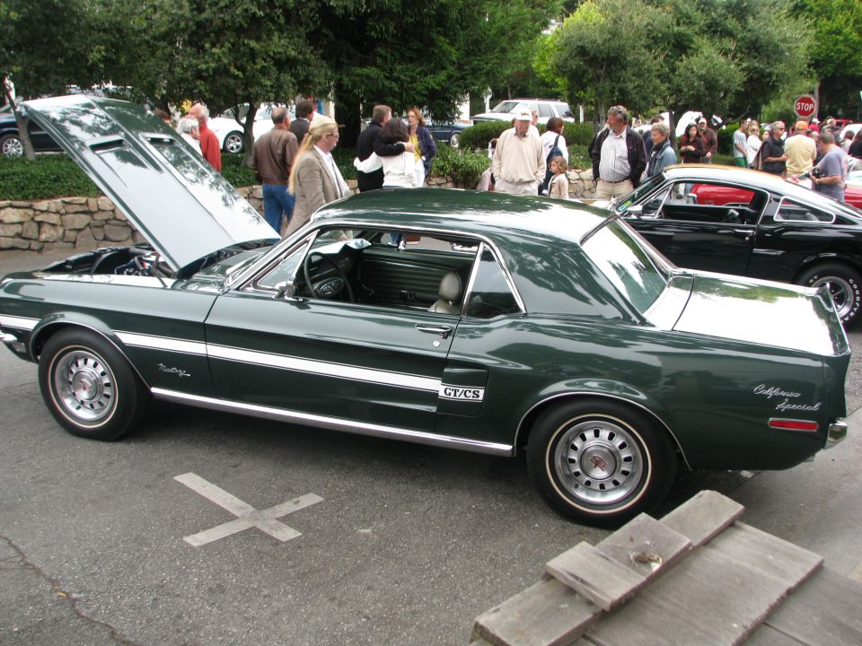 Green 1968 Ford Mustang GT/CS California Special coupe, hood open, parked next to a black Mustang