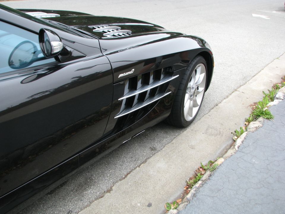 Black sports car fender with McLaren badging and side vent
