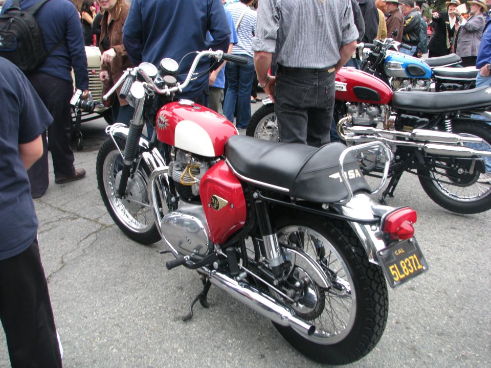 Red and white motorcycle with black seat, chrome accents, and a license plate reading 5L837L