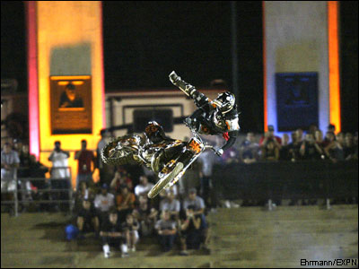1990 Ford Bronco - A motocross rider performs an aerial stunt during an event, with a crowd watching.