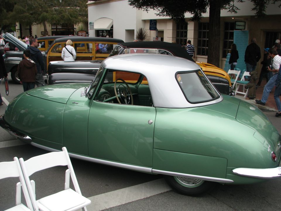 Green vintage convertible with silver roof at outdoor car show, rear 3/4 view