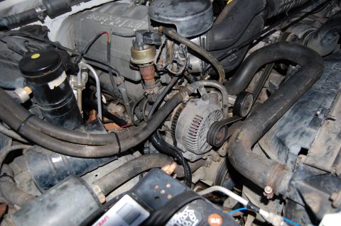 1994 Ford Bronco - Close-up view of an engine bay, focusing on the alternator and associated hoses. Text on the image indicates 'SUPERMOTORS'.