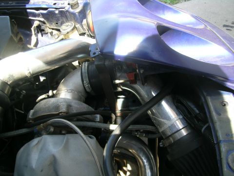 1995 Ford Probe - Close-up view of a modified engine bay, showing custom turbocharger plumbing and intercooler piping.