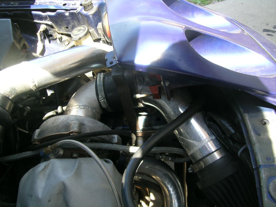 Purple car engine bay with large intercooler piping and turbocharger. Visible text: SUPERMOTORS