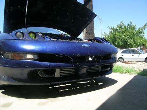 1995 Ford Probe - Front view of a blue 1995 Ford Probe with its hood open, revealing engine components and an intercooler.