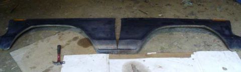 1978 Ford Bronco - Pair of fender flares shown on the ground. A hammer is visible next to them.