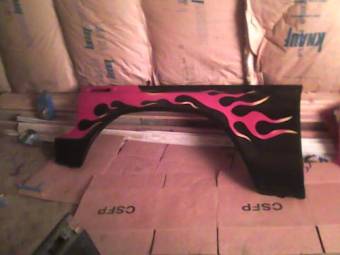 1978 Ford Bronco - A black fender flare with flame decals is shown, resting on cardboard.