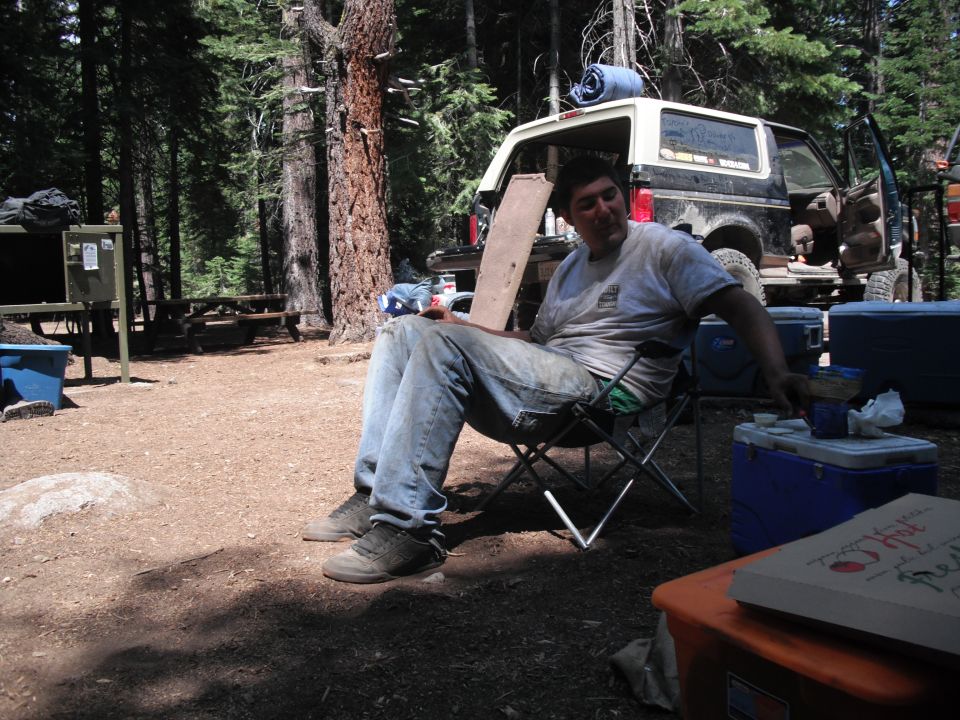 1991 Ford Bronco parked in a wooded campsite with its rear door open