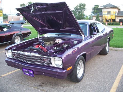 1971 Ford Ranchero - This purple muscle car, possibly a 1971 Ford Ranchero, is displayed with its hood open, revealing the engine compartment.