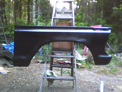 1978 Ford Bronco - A black rear fender is shown mounted on a ladder, likely awaiting further restoration or installation.