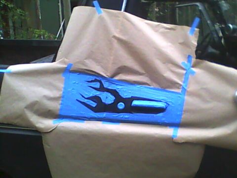 1978 Ford Bronco - flame design cut from blue painter's tape and brown masking paper, taped over a vehicle interior panel in preparation for painting.