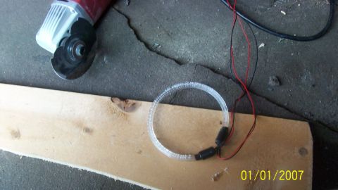2004 Ford Crown Victoria - Angle grinder and LED ring light on a wooden plank, possibly for a custom car lighting project.