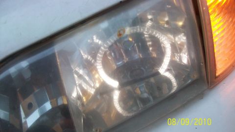 2004 Ford Crown Victoria - Headlight assembly showing internal components and amber turn signal light.
