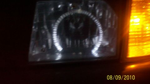 2004 Ford Crown Victoria - A close-up shot focuses on a car's headlight assembly, highlighting a distinctive halo ring light.