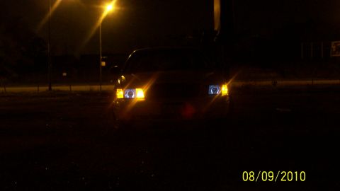 2004 Ford Crown Victoria - Front view of a 2004 Ford Crown Victoria at night, illuminated by its headlights.