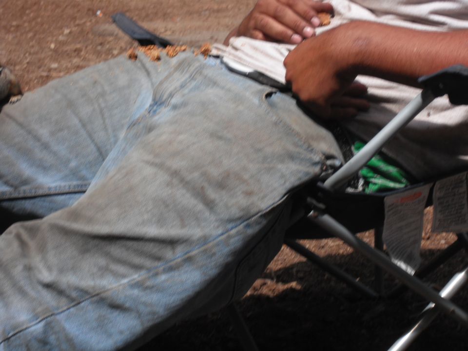 Person sitting in a camping chair, food spilled on jeans