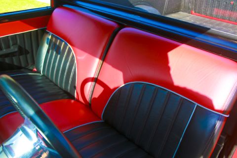1959 Ford Ranchero - Interior view of a car's red and black bench seat with chrome accents.