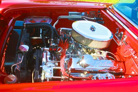1959 Ford Ranchero - The engine bay of a red car features a polished V8 engine with custom chrome components.