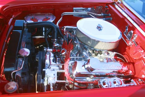 1959 Ford Ranchero - The engine bay of a red 1959 Ford Ranchero is detailed with chrome components.