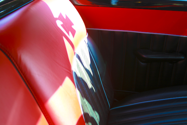 Red and black interior of a 1959 Ford Ranchero with a prominent seat