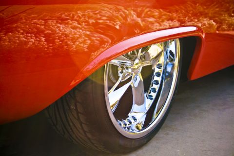 1959 Ford Ranchero - Close-up of a 1959 Ford Ranchero's orange paint and chrome wheel.