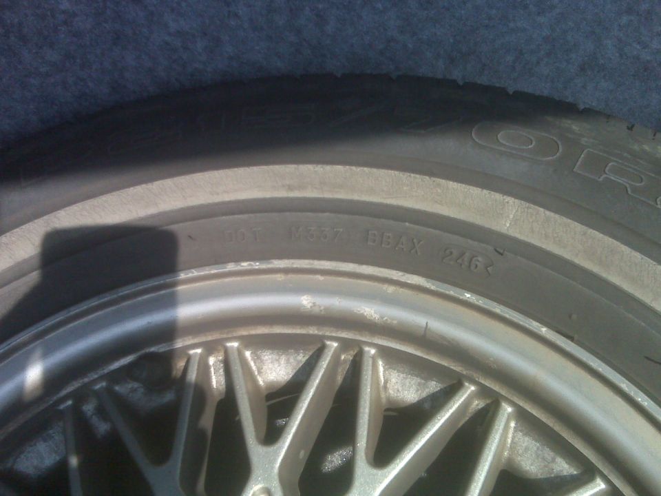 Close-up of a tire with DOT code and a silver alloy wheel