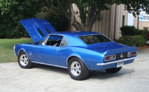 1976 Ford Ranchero - A blue 1967 Chevrolet Camaro coupe is shown from a three-quarter front angle with its hood open.