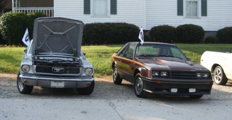1976 Ford Ranchero - Two Ford Mustangs, one from the 1970s and another from the 1980s, are parked outside a house.