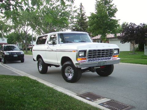 1978 Ford Bronco - A white 1978 Ford Bronco is parked on a street, with another vehicle visible in the background.