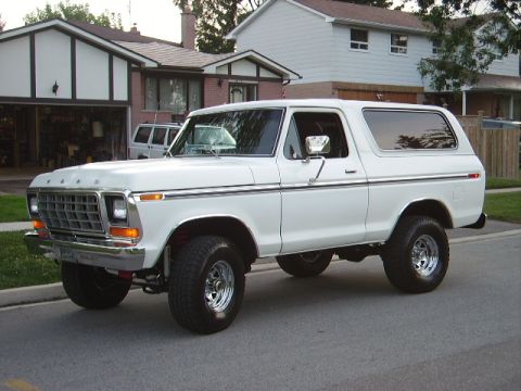 1978 Ford Bronco - A white 1978 Ford Bronco is parked on a suburban street in front of houses.