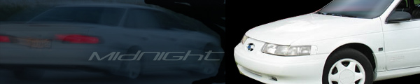 White 1993 Ford Taurus front quarter view next to a dark sedan's rear
