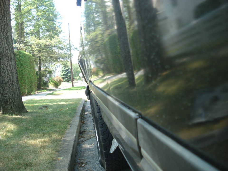 Side body line of a dark vehicle along a residential street