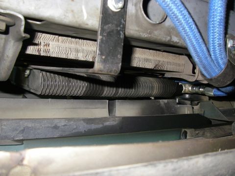1990 Ford Bronco - Close-up view of the transmission cooler lines and radiator fins within a vehicle's engine bay.