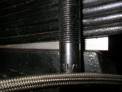 1990 Ford Bronco - A close-up view shows a threaded metal component with the number '20170' stamped on it, likely part of a vehicle's suspension system.