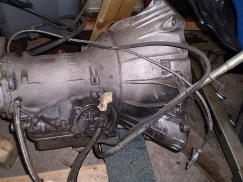 1978 Ford Bronco - A close-up view of a vehicle transmission, showing its metallic casing and various attached components.