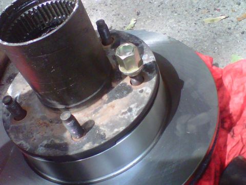 1995 Ford Bronco - Close-up view of a wheel hub with splines and a brake rotor, showing the mounting studs and lug nut.