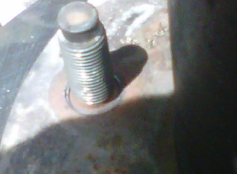1995 Ford Bronco - A close-up view of a single wheel stud, showing its threaded shaft and the surrounding metal surface.