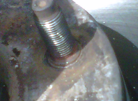 1995 Ford Bronco - A close-up view of a brake rotor pressing, showing a threaded bolt and metallic texture.