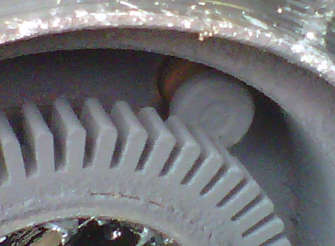 1995 Ford Bronco - Extreme close-up of the toothed teeth of an ABS tone ring with the rounded end of a wheel stud lying across it, showing the interference be…