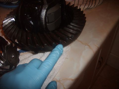1989 Ford Bronco - Close-up of a differential gear set, with a gloved hand indicating a specific area.
