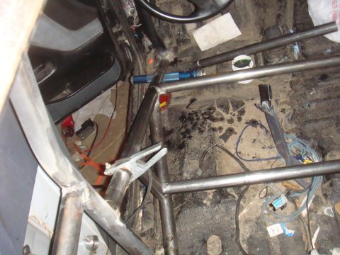 1992 Ford Bronco - The interior of a vehicle is shown with a custom roll cage, obscuring most of the original interior features.