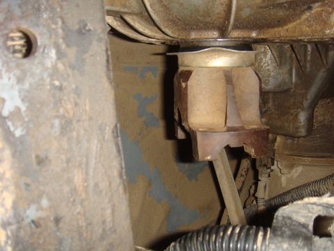 1992 Ford Bronco - A close-up view of a vehicle's engine mount, revealing its worn condition and surrounding mechanical components.