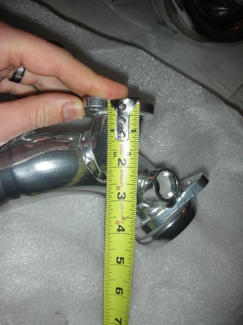 1998 Ford Crown Victoria - A hand holds a tape measure against a chrome exhaust pipe, indicating its dimensions.