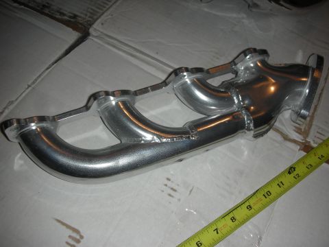 1998 Ford Crown Victoria - A polished aluminum exhaust manifold is shown with a yellow tape measure for scale.