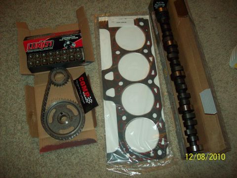 1985 Ford Bronco - Engine parts laid out on a carpeted floor, including a camshaft, timing set, and head gasket.