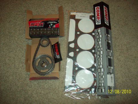 1985 Ford Bronco - Various engine components are laid out on a carpeted surface, including a timing set and gasket kit.