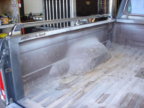 1979 Ford F-250 - View of the inside of a truck bed, showing the wheel wells and a roll bar.
