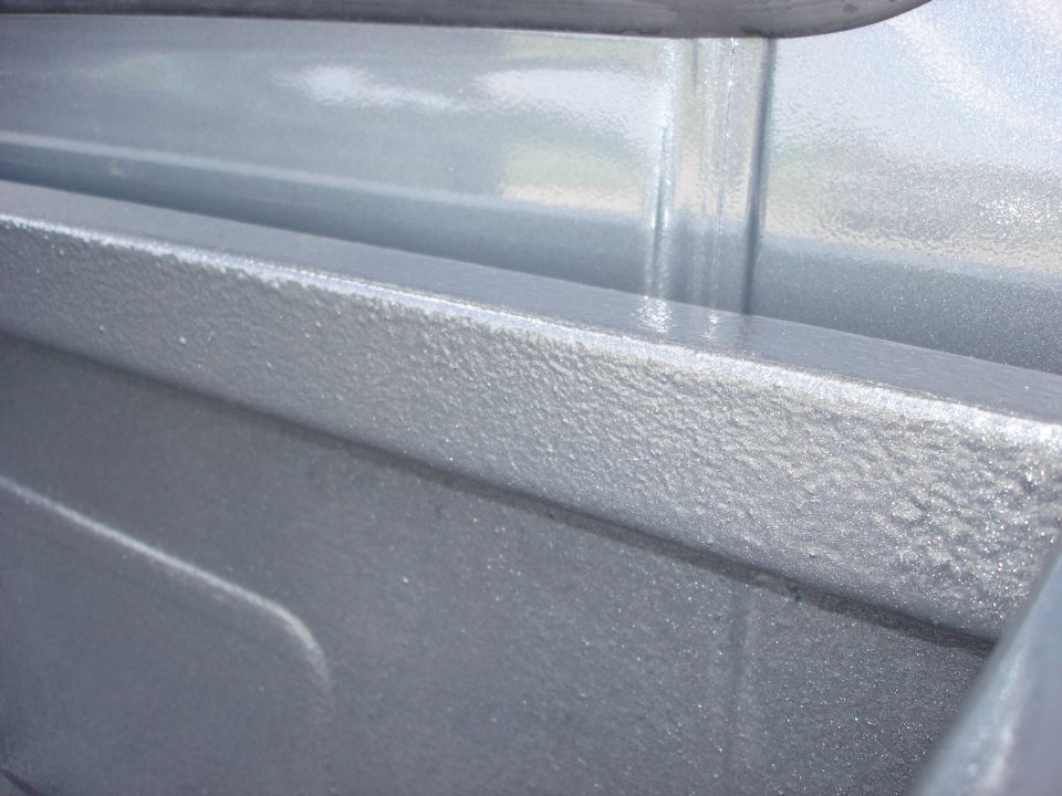 Close-up of a gray textured truck bedliner with a Supermotors.net watermark
